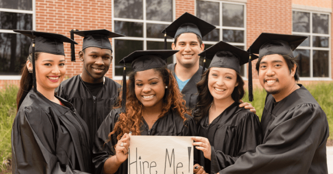 Graduates holding a Hire Me sign